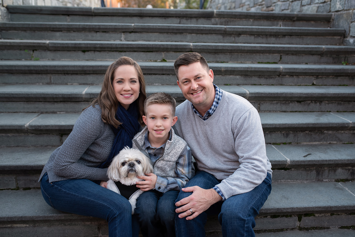 Family posing with dog on steps in Frederick, Maryland